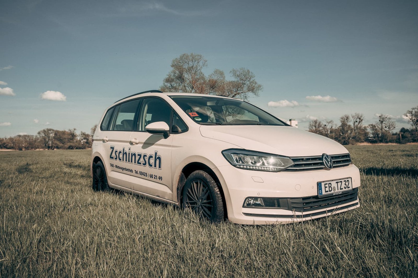 Weißer VW Touran von Taxi Zschinzsch mit Firmenbeschriftung und Telefonnummer